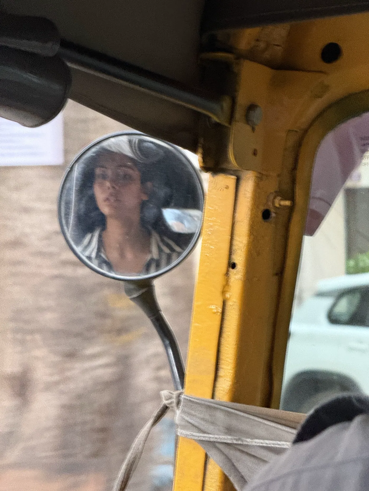 Aiko reflected in an auto-rickshaw wing mirror